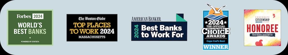 Several people are gathered together indoors, smiling and holding a large ceremonial check.